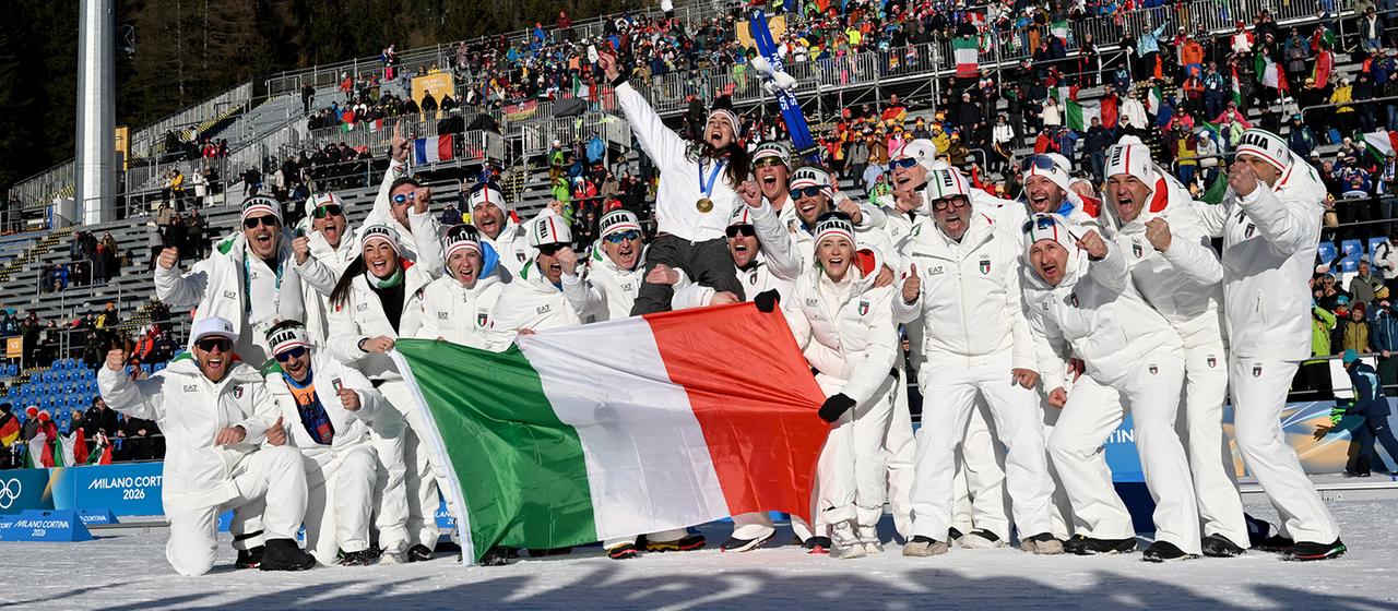 Lisa Vittozzi feiert den Gewinn einer Goldmedaille mit ihrem Team.