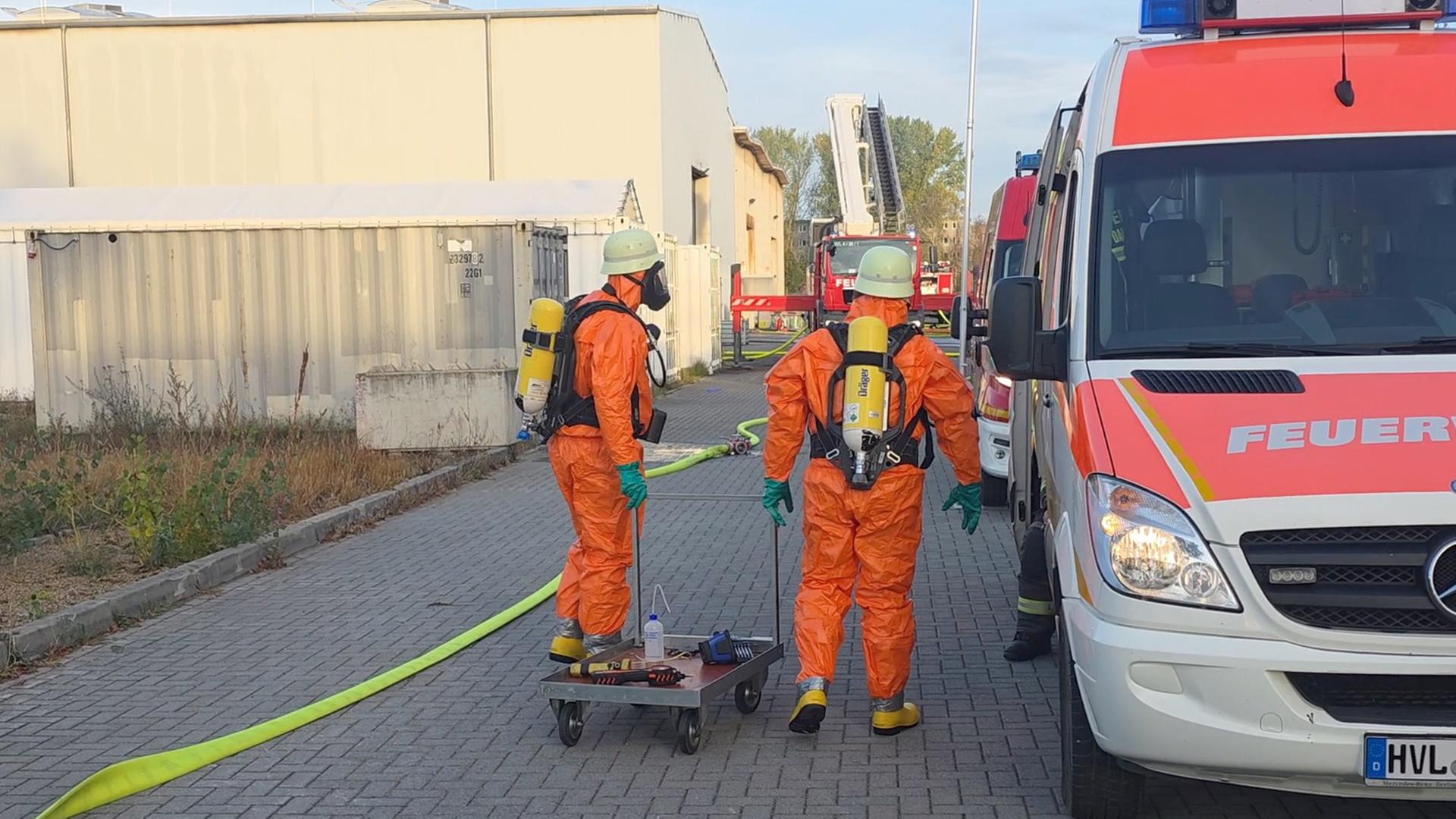 Kräfte in Schutzkleidung sind auf dem Gelände eines Recycling-Unternehmens im havelländischen Premnitz im Einsatz. (Quelle: nonstopnews) | nonstopnews