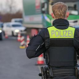 Ein Polizeibeamter beobachtet den Verkehr an einer Kontrollstelle.