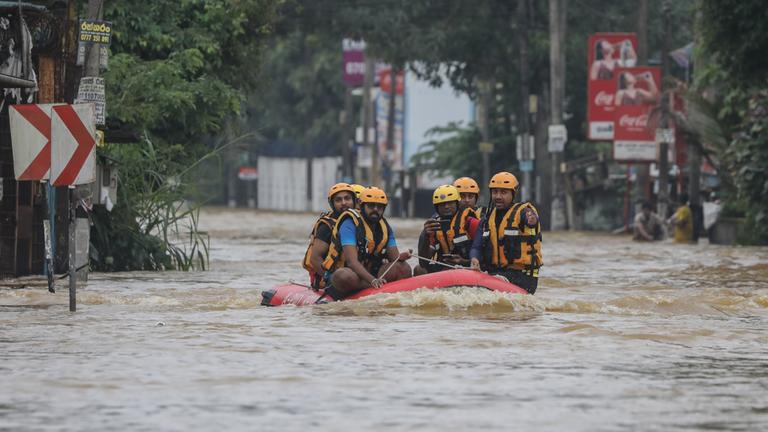 Rettungskräfte fahren auf überfluteten Straßen in einem Schlauchboot durch einen Vorort von Colombo, Sri Lanka