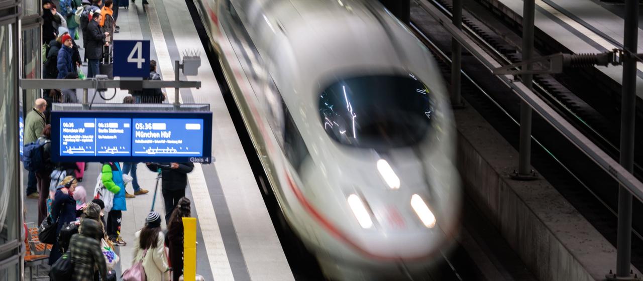 Reisende warten im Berliner Hauptbahnhof auf einen ICE nach München