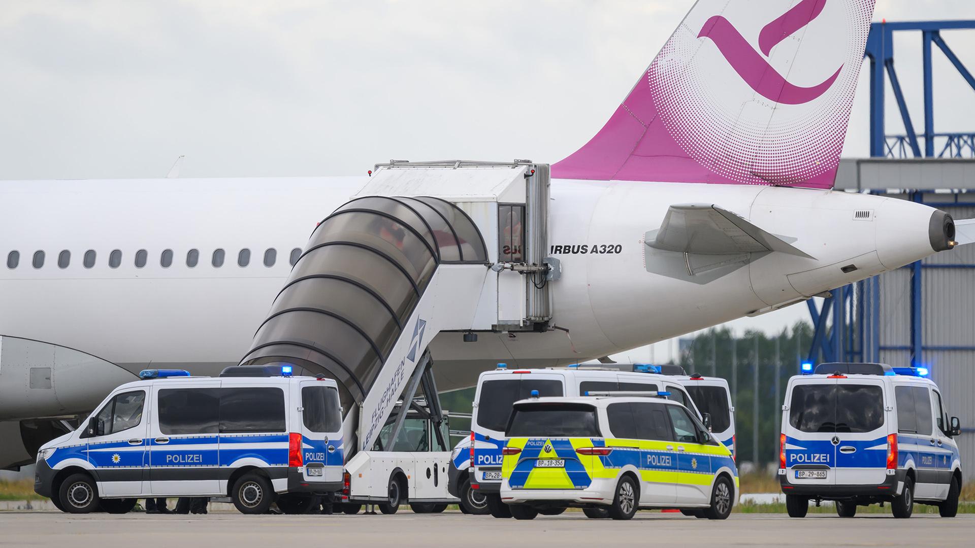 Polizeifahrzeug fahren auf dem Flughafen Leipzig/Halle an einem Airbus vor.  Am Airport stand am Morgen des 22.07.2025 eine Maschine mit dem Ziel Bagdad bereit. (Quelle: dpa-Bildfunk/Hendrik Schmidt) | dpa-Bildfunk/Hendrik Schmidt