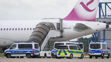 Polizeifahrzeug fahren auf dem Flughafen Leipzig/Halle an einem Airbus vor.  Am Airport stand am Morgen des 22.07.2025 eine Maschine mit dem Ziel Bagdad bereit. (Quelle: dpa-Bildfunk/Hendrik Schmidt)