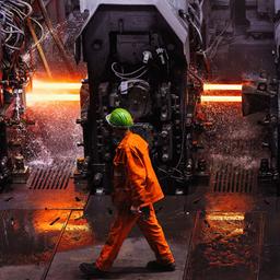 Ein Mitarbeiter der Badischen Stahlwerke GmbH (BSW) geht durch das Walzwerk der Firma.