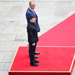 Wolodymyr Selenskyj (vorne) und Friedrich Merz (hinten) stehen auf einem roten Teppich.