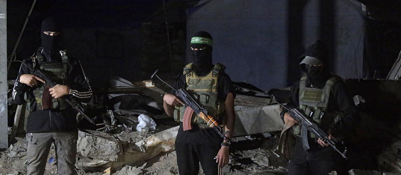 Palästinensische Kämpfer der Izz ad-Din al-Qassam-Brigaden der Hamas bewachen Fahrzeuge des Internationalen Komitees vom Roten Kreuz in Gaza-Stadt. | EPA Palästinensische Kämpfer der Izz ad-Din al-Qassam-Brigaden der Hamas bewachen Fahrzeuge des Internationalen Komitees vom Roten Kreuz in Gaza-Stadt.