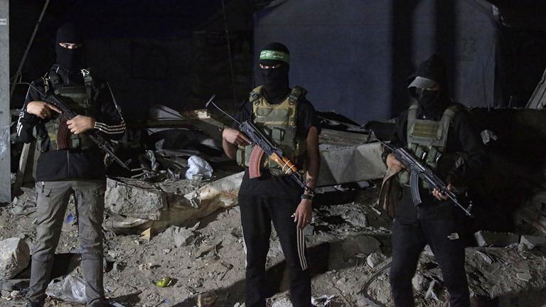 Palästinensische Kämpfer der Izz ad-Din al-Qassam-Brigaden der Hamas bewachen Fahrzeuge des Internationalen Komitees vom Roten Kreuz in Gaza-Stadt.