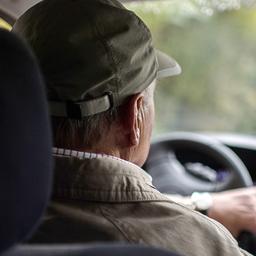 Ein Rentner sitzt am Steuer eines Autos.