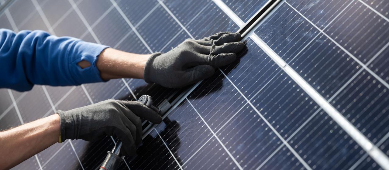 Arbeiten an den Solarmodulen einer Photovoltaik-Anlage