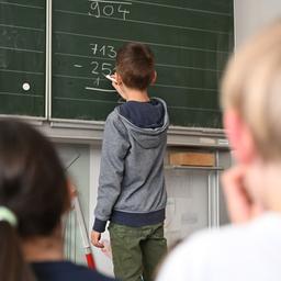 Schüler einer Grundschüler arbeiten in einem Klassenzimmer an einer Mathematikaufgabe. 