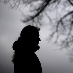 Eine Frau steht neben einem Baum