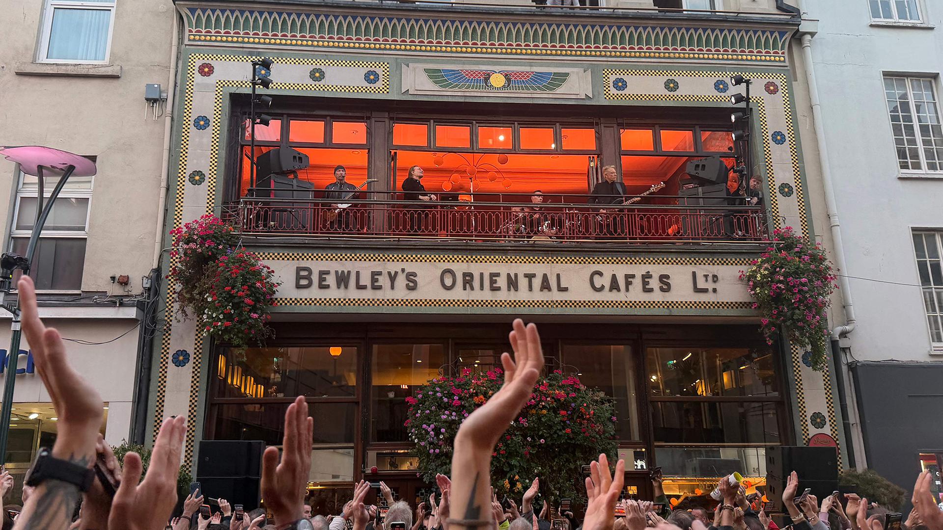 Fans jubeln vor einem Pub, auf dessen Balkon die Rockband U2 auftritt. | AFP