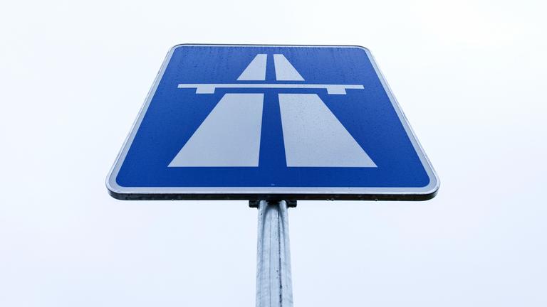 Ein rechteckickes Autobahnschild mit einem blauen Hintergrund und einem weißem Autobahnsymbol.