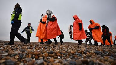 Britische Offizielle begleiten im Dezember Migranten an einem Strand in Südostengland.
