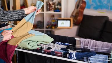 Eine Frau legt Wäsche zusammen