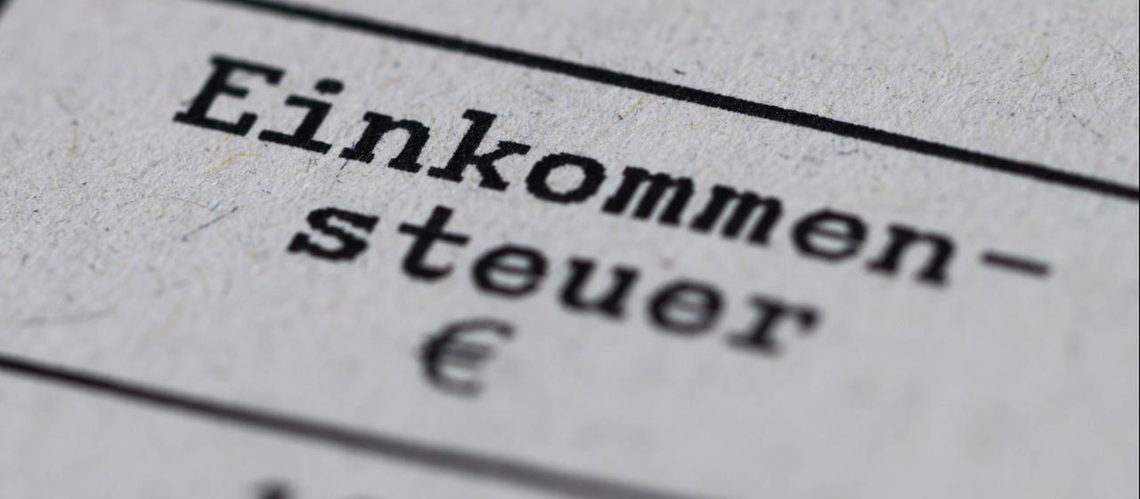 in Steuerbescheid mit dem Vermerk "Einkommensteuer" liegt auf einem Tisch.