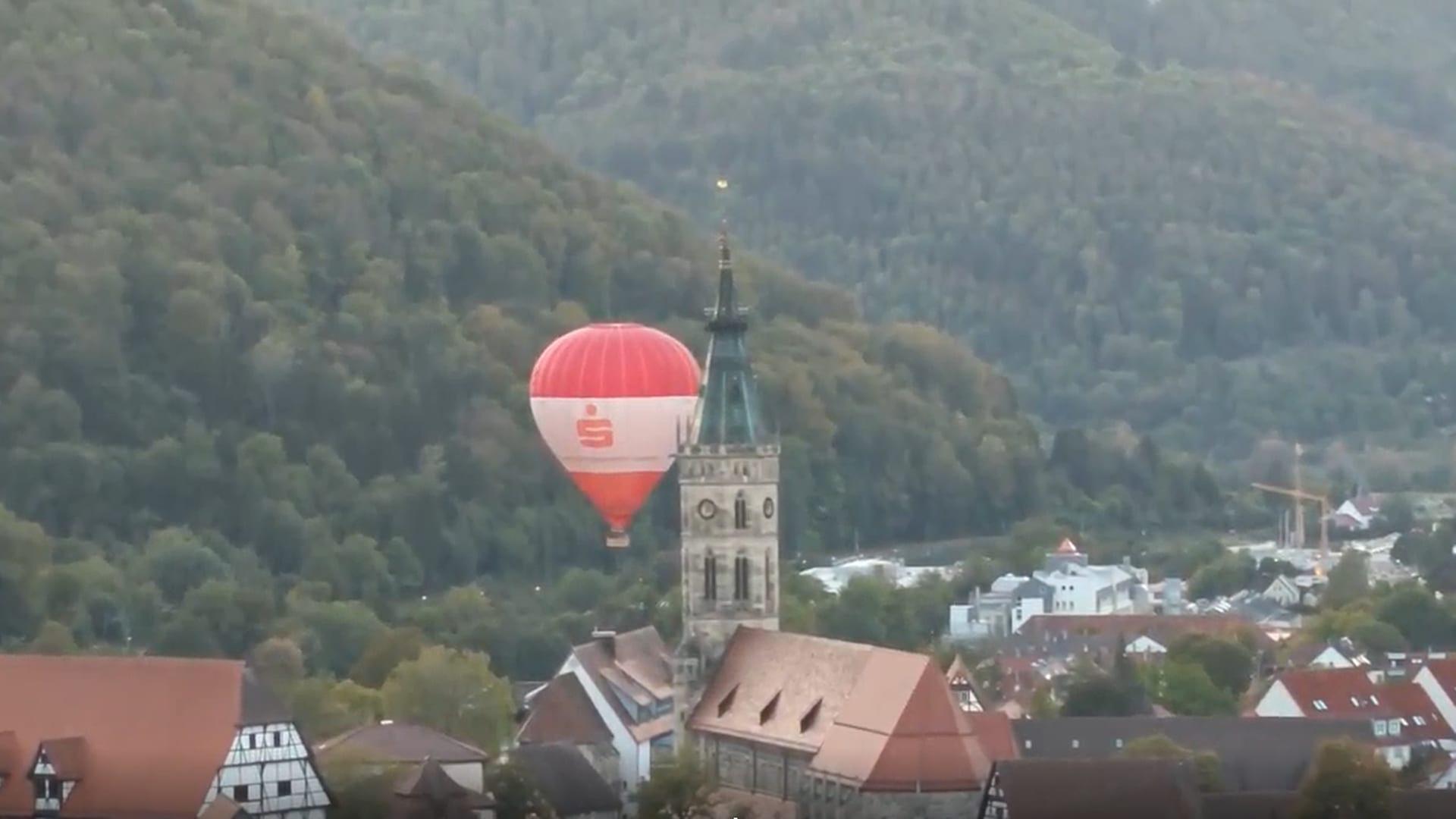 Ein Heißluftballon fährt in Bad Urach dicht an einem Kirchturm vorbei. | Siegfried Keßler