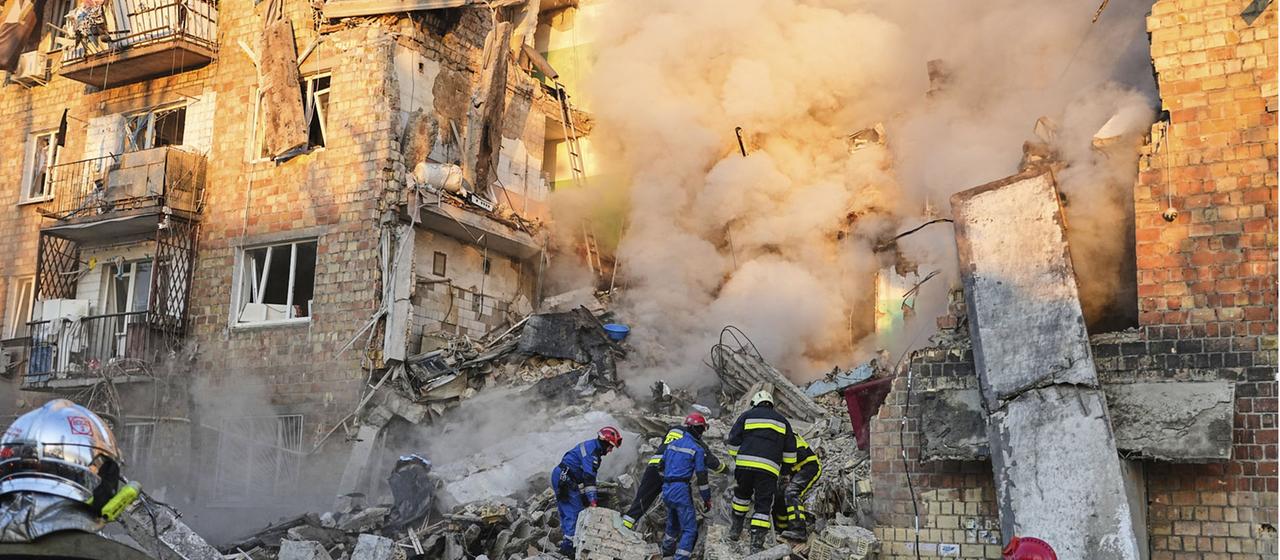 Feuerwehrleute arbeiten an einem brennende Gebäude in Kiew, Ukraine. | AP Feuerwehrleute arbeiten an einem brennende Gebäude in Kiew, Ukraine.