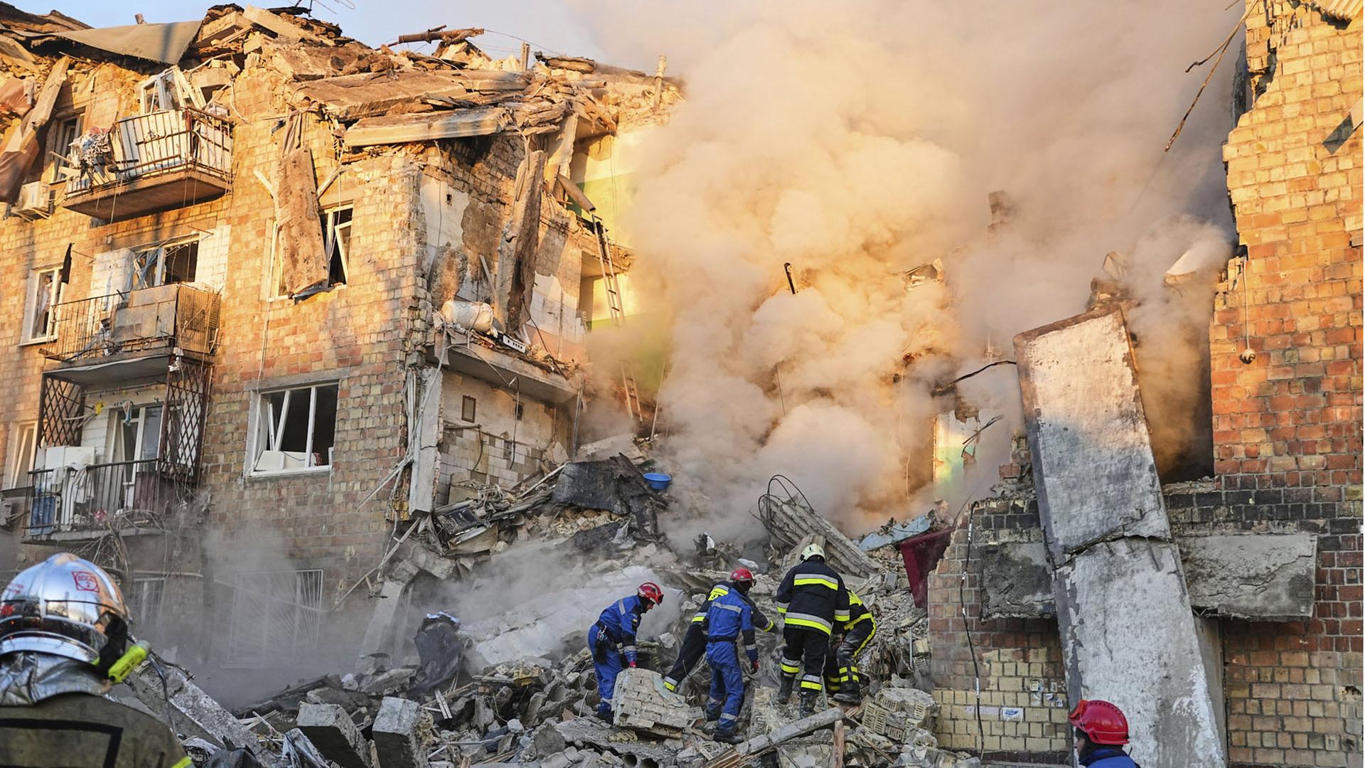 Feuerwehrleute arbeiten an einem brennende Gebäude in Kiew, Ukraine.  | AP