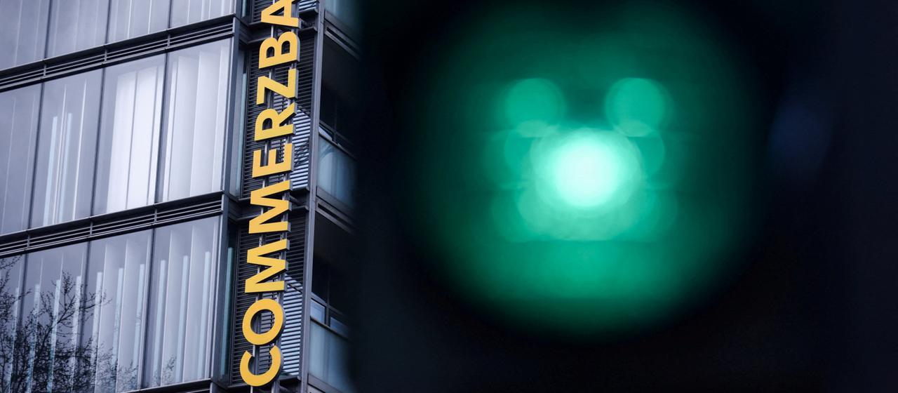 In der Nähe eines Commerzbank-Logos leuchten Ampeln.