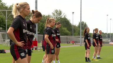 Fußballerinnen stehen im Training am Spielfeldrand