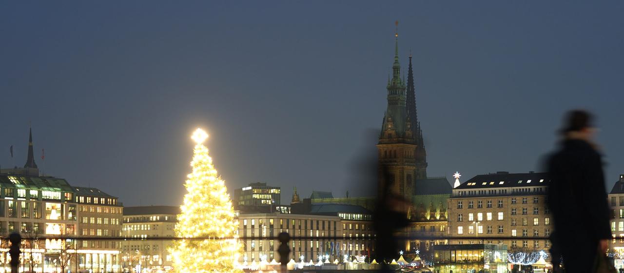   A brightly lit Christmas tree stands on the Binnenalster in Hamburg231225.