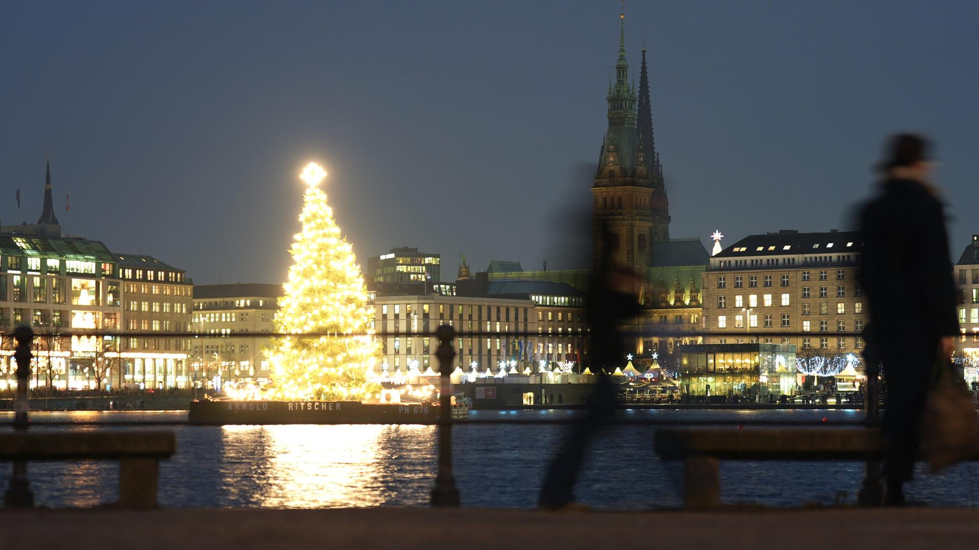 Hell erleuchtet steht ein Weihnachtsbaum auf der Binnenalster in Hamburg231225. | dpa