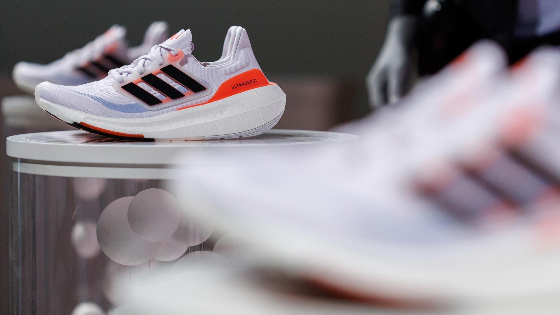 Das Logo und der Schriftzug des Sportartikelherstellers adidas AG ist am Rande der Hauptversammlung des Unternehmens auf einem ausgestellten Schuh zu sehen. | picture alliance/dpa