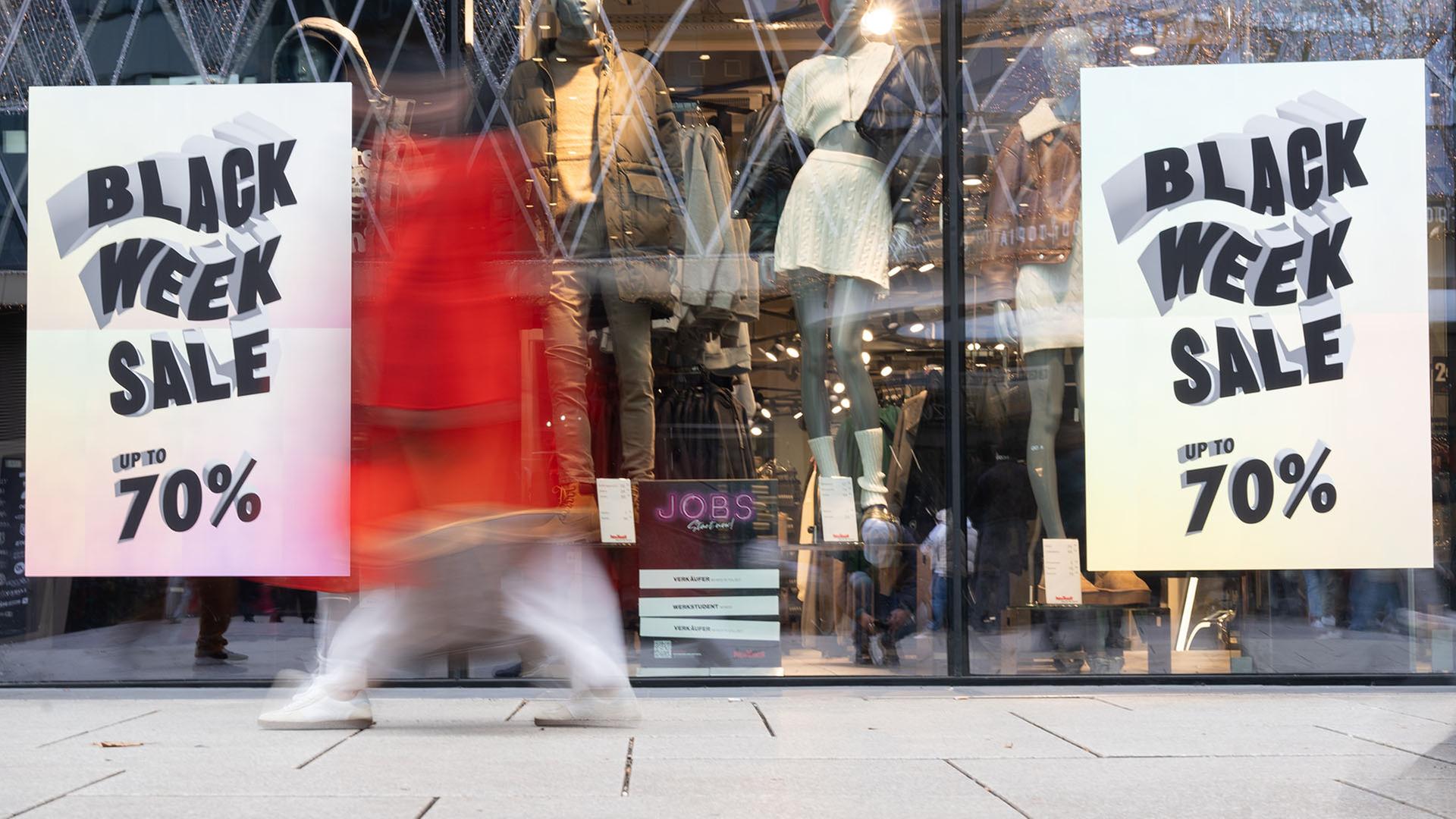 Eine Person geht an einem Schaufenster mit der Aufschrift 