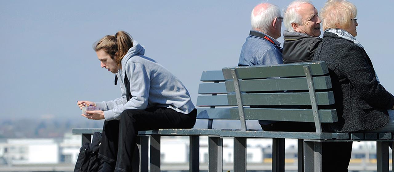Ein junger Mann und Rentner in der Frühlingssonne