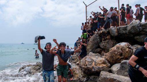 Migranten überqueren die Grenze von Marokko in die spanische Exklave Ceuta.