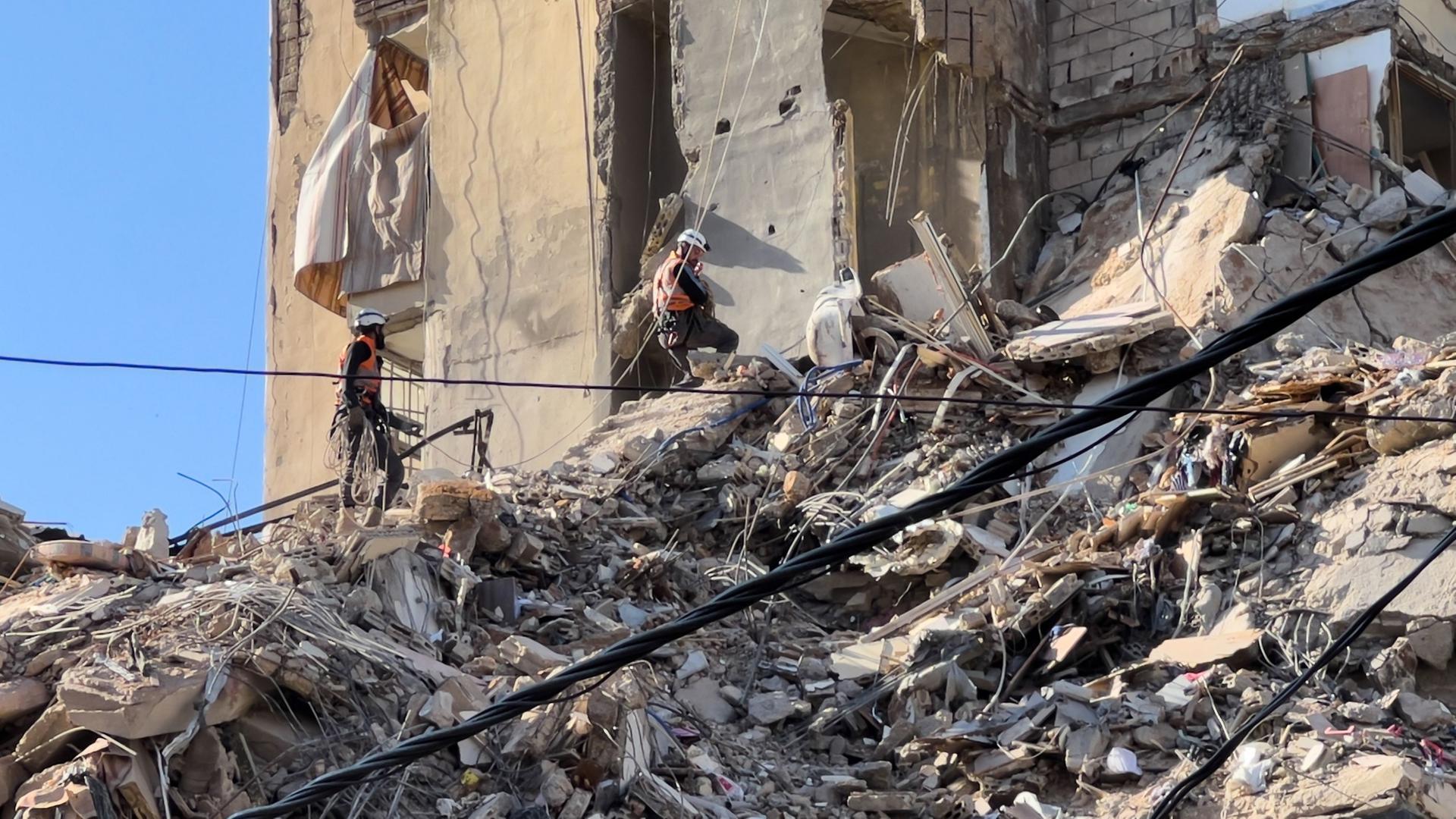 Rettungskräfte durchsuchen die Trümmer eines zerstörten Gebäudes, das bei einem israelischen Luftangriff in einem südlichen Vorort von Beirut getroffen wurde. | Hussein Malla/AP/dpa
