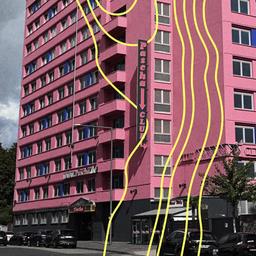 Wir sehen ein großes Haus, welches pink gestrichen ist.