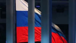 Eine russische Flagge weht hinter einem Zaun.