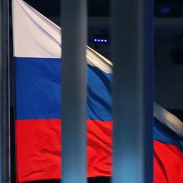 Eine russische Flagge weht hinter einem Zaun.