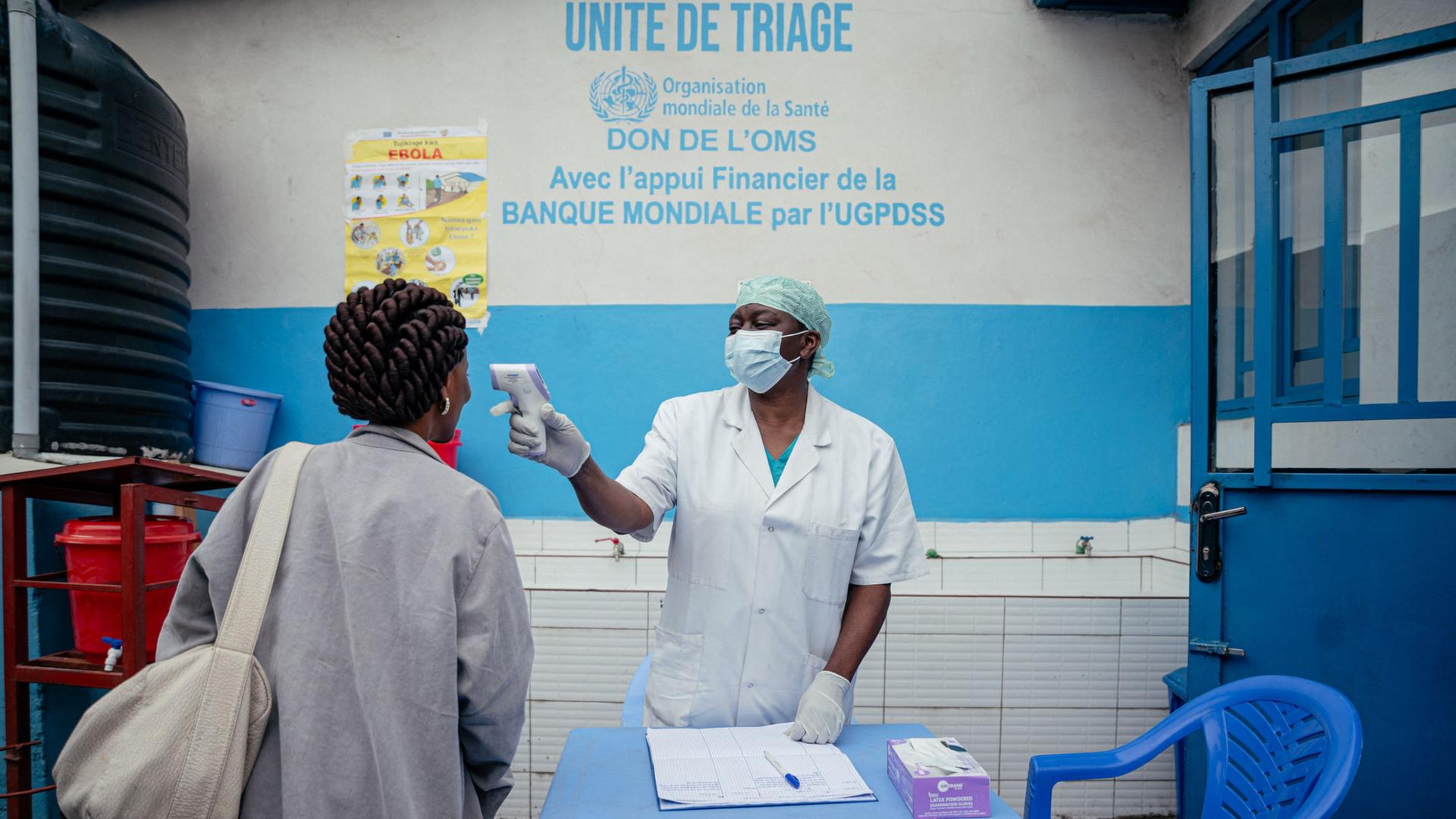 Eine Ärztin misst die Temperatur einer Frau in einem Krankenhaus in der DR Kongo. | AFP