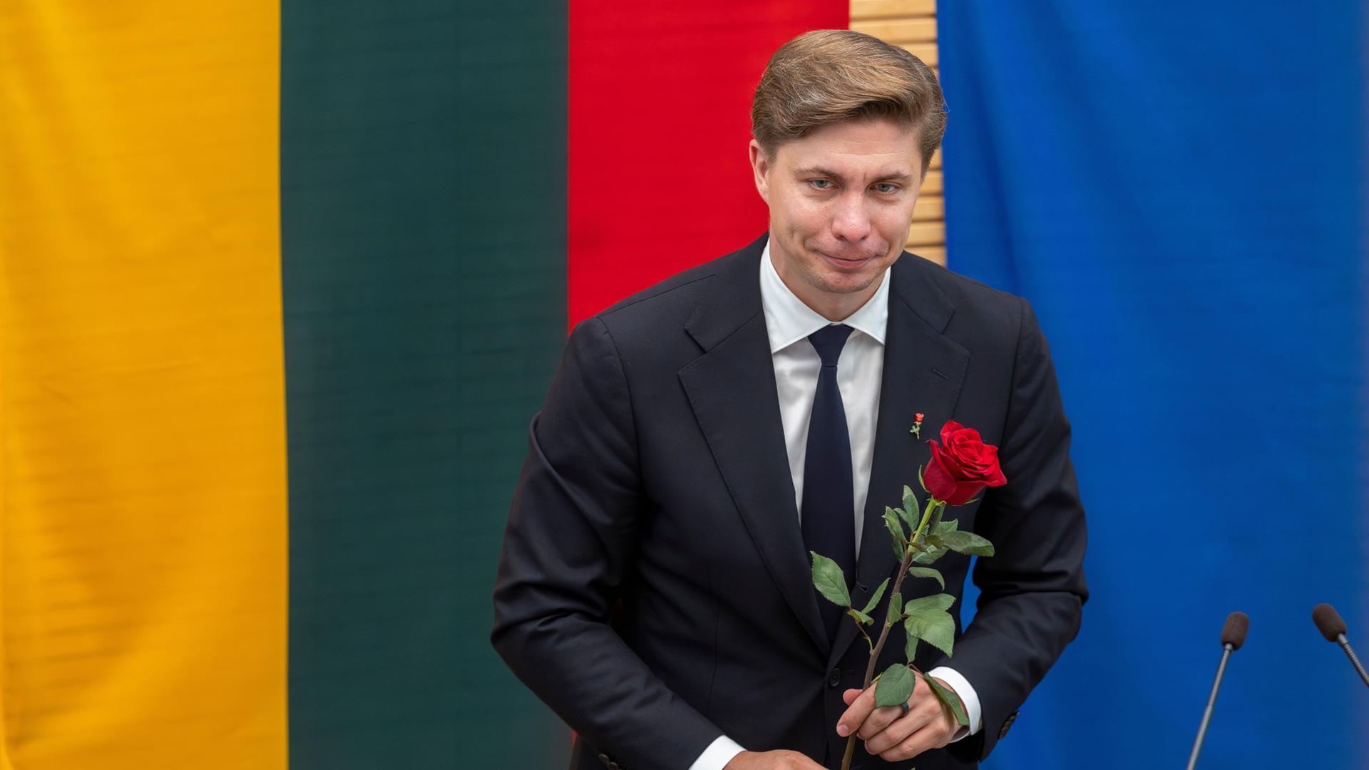 Mindaugas Sinkevicius mit einer roten Rose in der Hand | Mindaugas Kulbis/AP/dpa