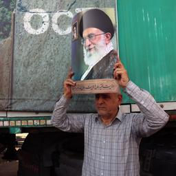 Auf einer Kundgebung in Teheran (Iran) zeigt ein Mann ein Bild von Ajatollah Chamenei.