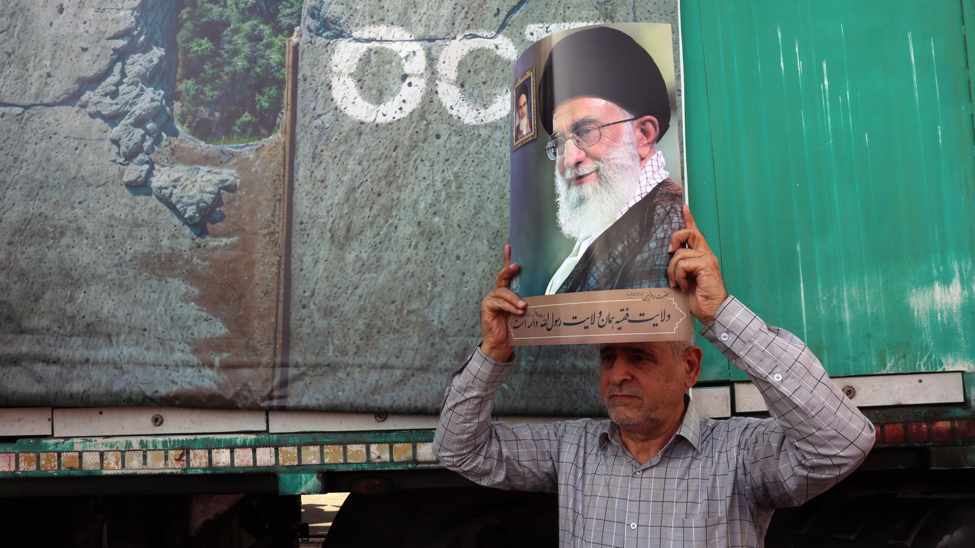 Auf einer Kundgebung in Teheran (Iran) zeigt ein Mann ein Bild von Ajatollah Chamenei. | EPA