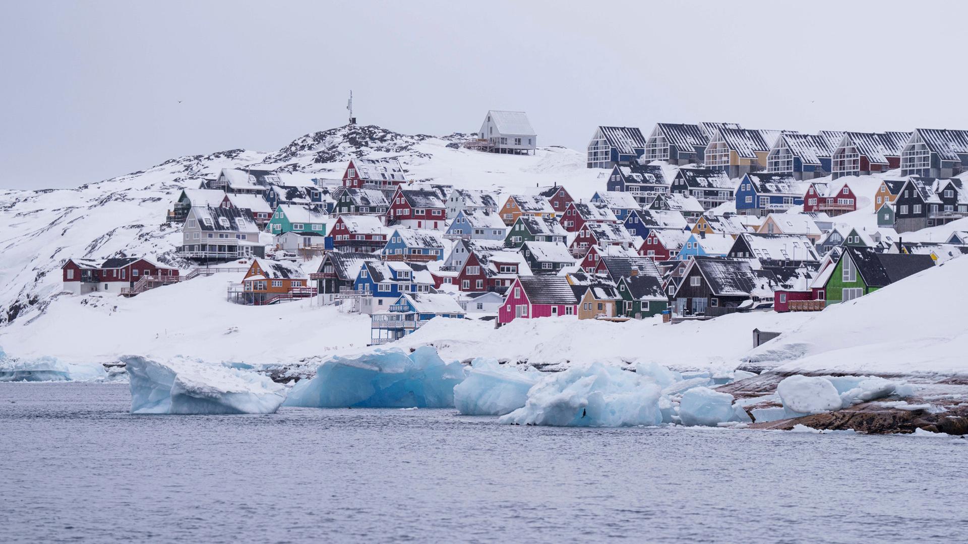 Bunte, schneebedeckte Häuser in Nuuk (Grönland) sind vom Meer aus zu sehen. | dpa