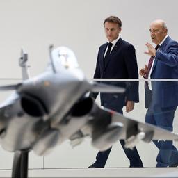 Eric Trappier (rechts) spricht mit Emmanuel Macron, im Vordergrund ist ein Modell eines Kampfjets zu sehen.