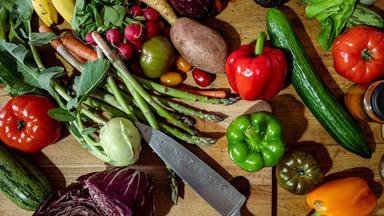 Verschiedenes Gemüse und Obst liegt auf einem Tisch.