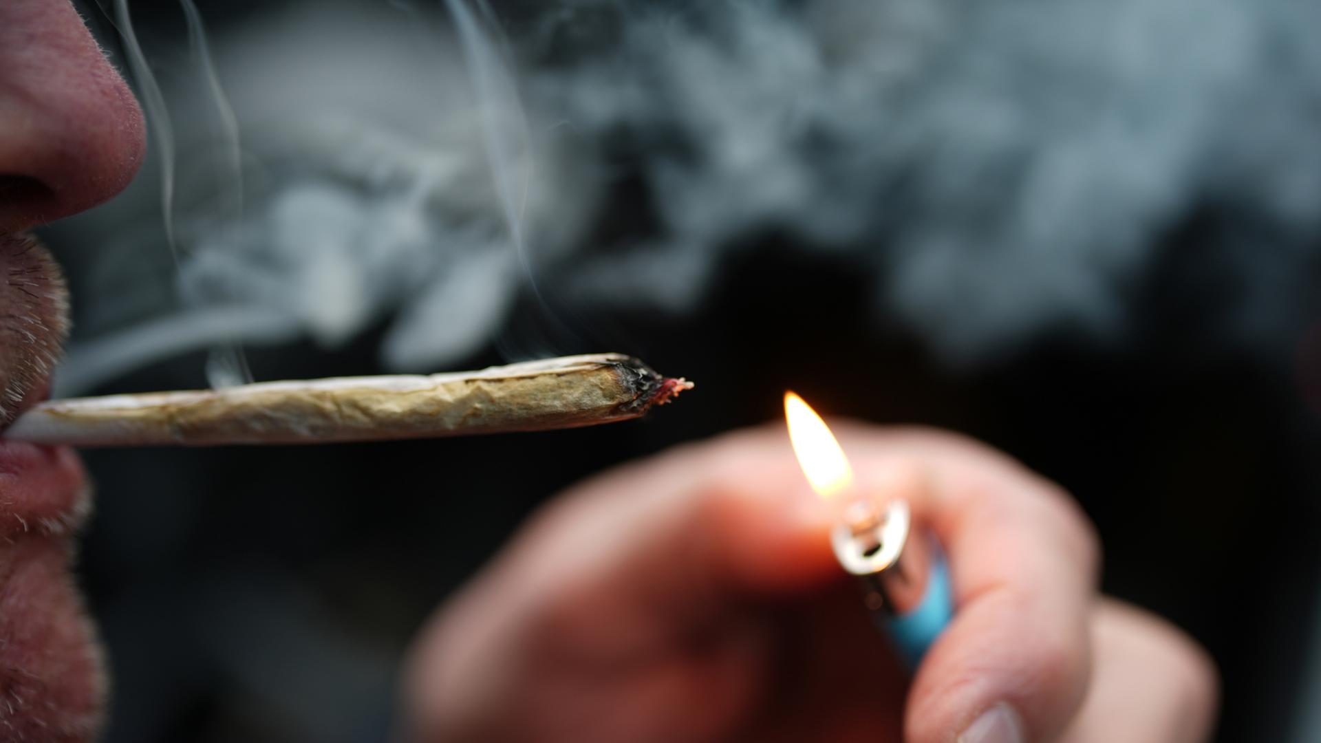 Ein Mann raucht einen Joint.