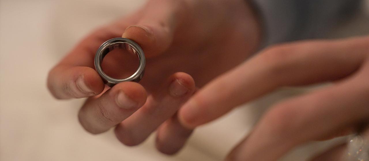 Eine Frau hält einen Oura-Ring in der Hand.