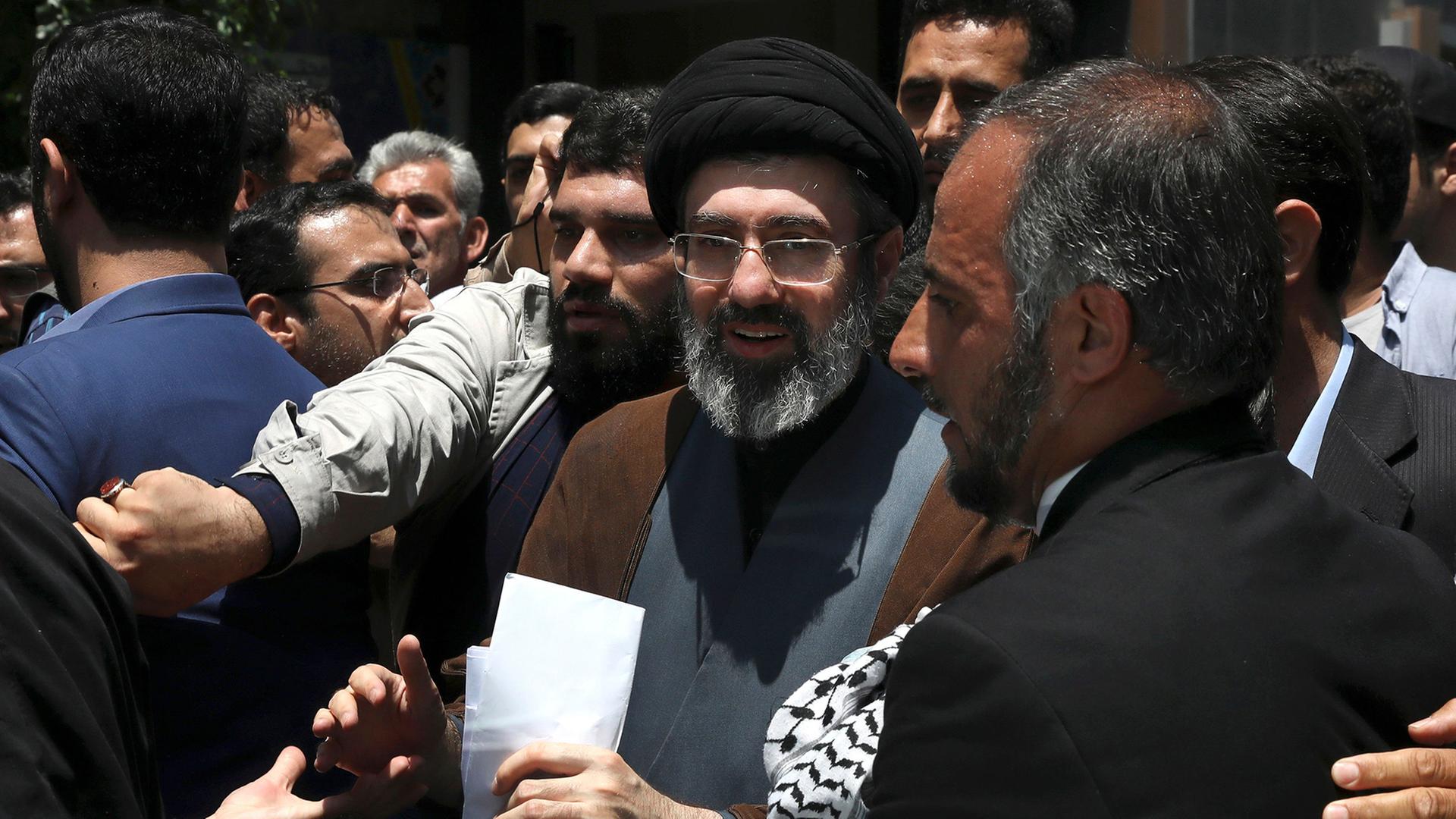 Mojtaba Khamenei Chamenei steht in einer Menschenmenge im Freien. | AP