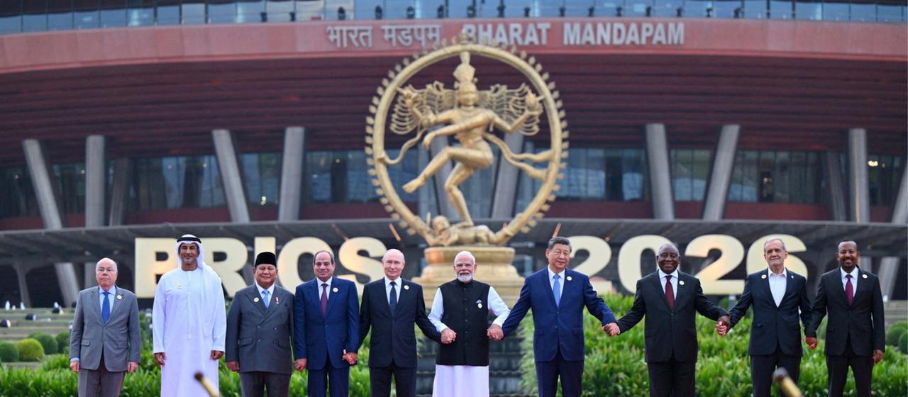 Teilnehmer des BRICS-Gipfels in Indien halten sich an den Händen