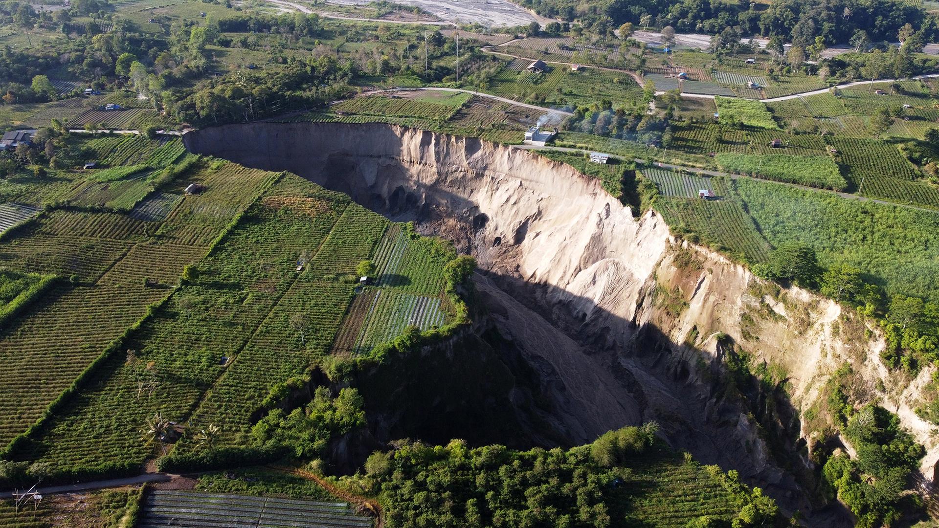 Ein mit einer Drohne aufgenommenes Bild zeigt einen riesigen Krater im Dorf Pondok Balik (Indonesien). | EPA