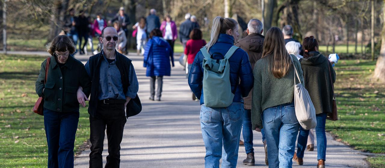 Spaziergänger gehen durch den Kurpark in Bad Nauheim.