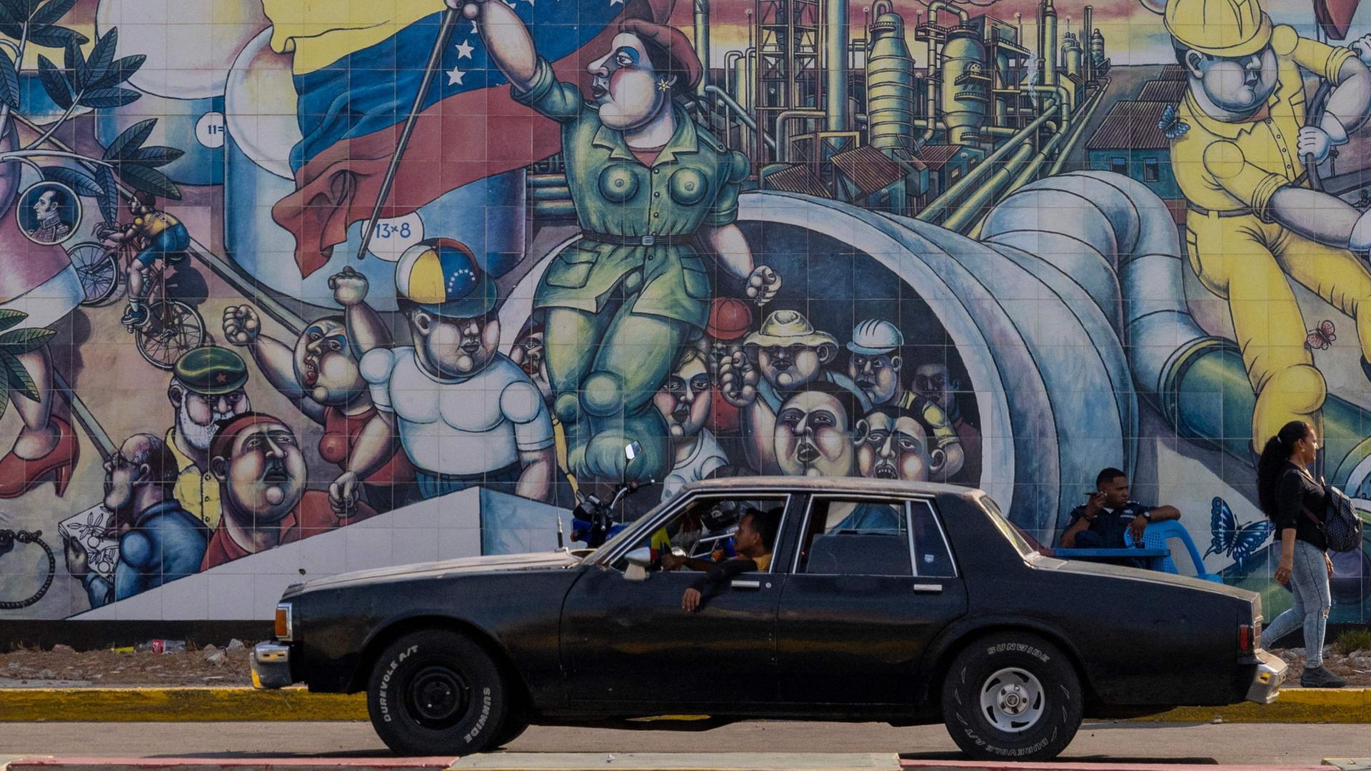 Ein Auto fährt in Maracaibo an einem Wandbild vorbei. | AFP