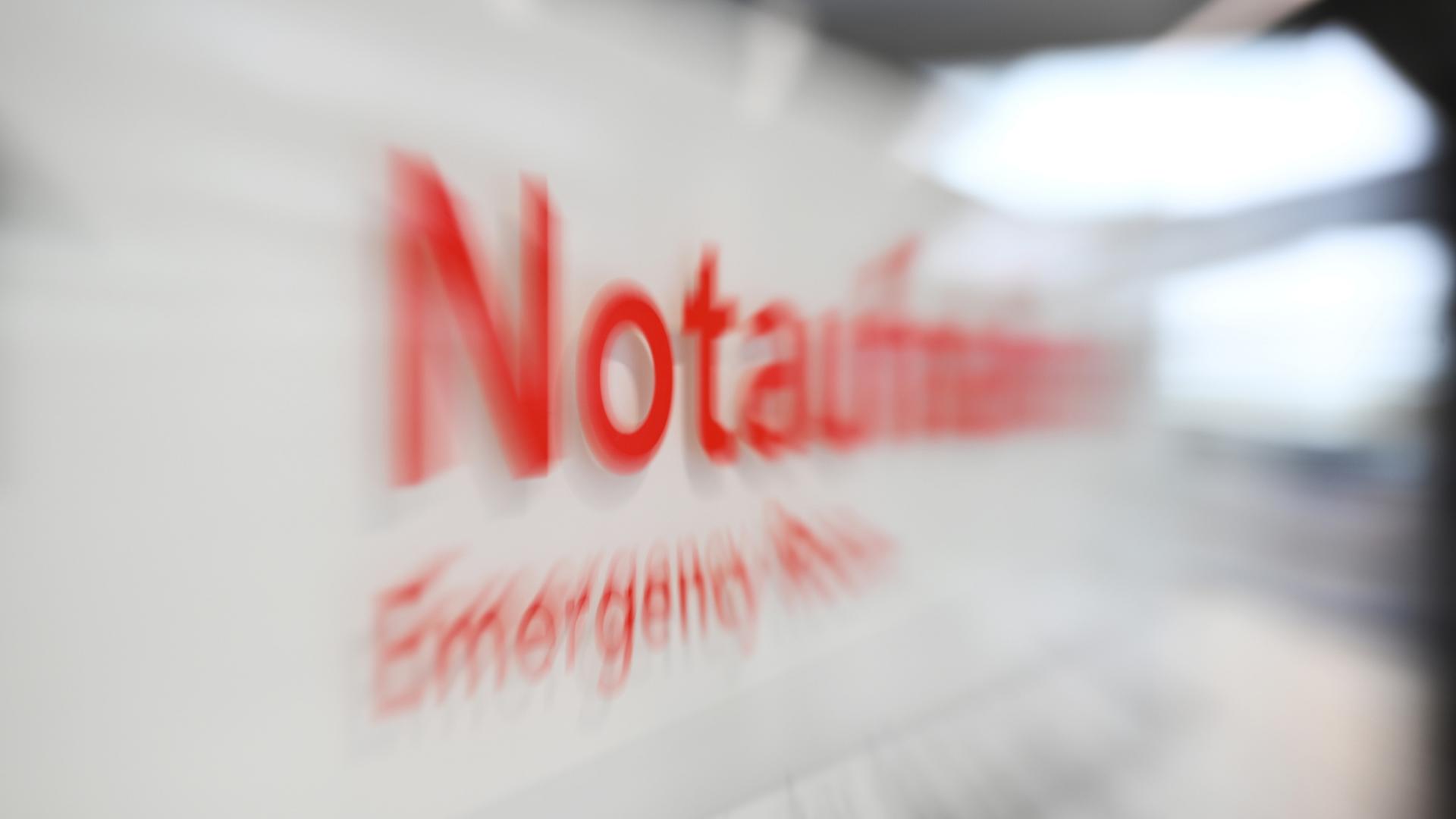 Auf einem Schild in einem Krankenhaus ist das Wort Notaufnahme verschwommen zu sehen | dpa